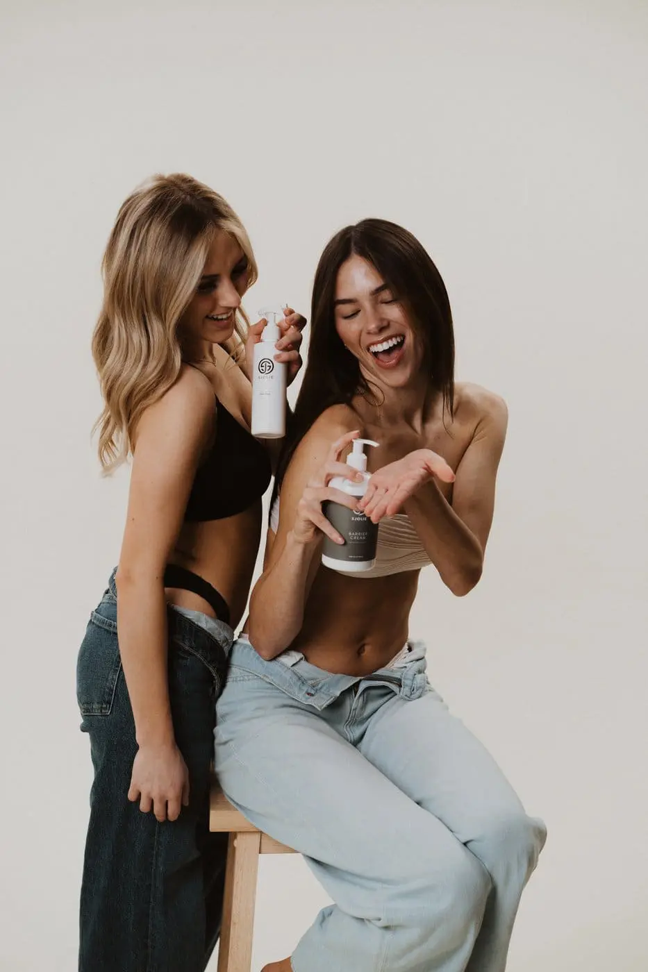 Professional spray tan artist applying Sjolie Barrier Cream during a session