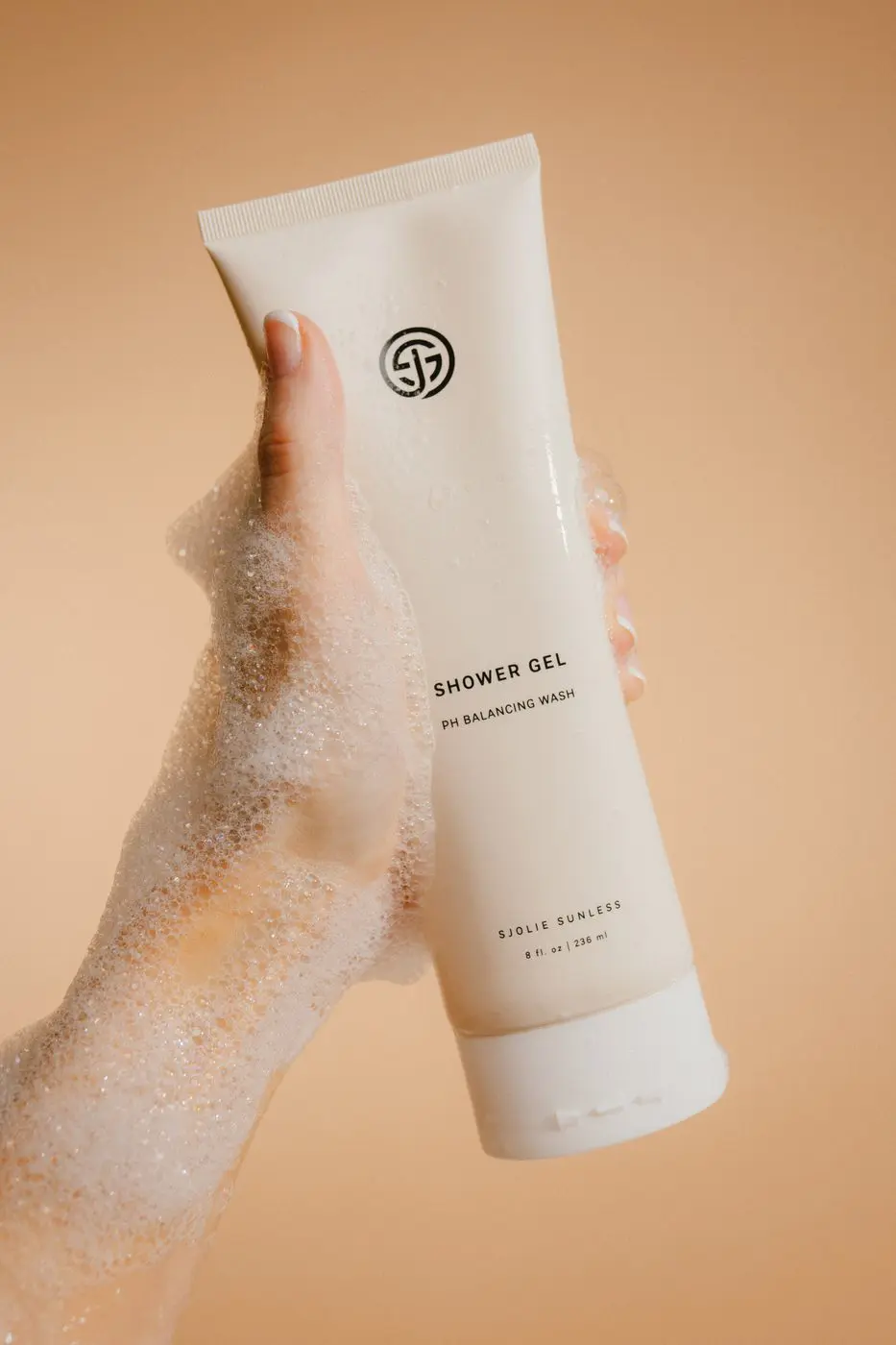 Hand holding Sjolie Shower Gel pH-balanced body wash with lather