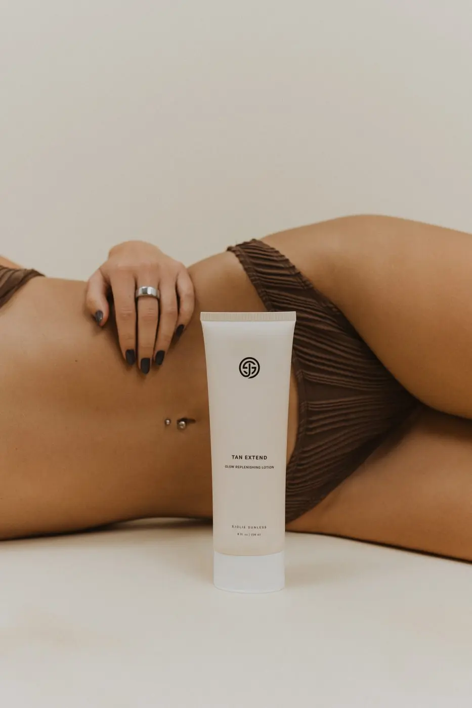 Model with Sjolie Tan Extend Glow Replenishing Lotion for daily spray tan maintenance