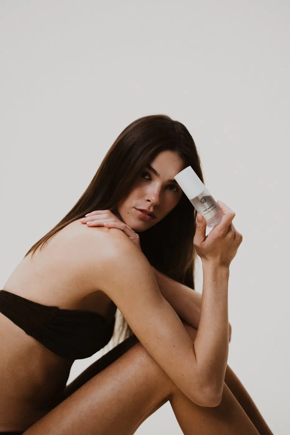 Model with Sjolie Tan Water self-tanning face mist for natural radiant glow