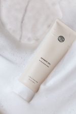 SJOLIE Shower Gel tube lying in white foamy lather