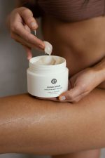 Woman scooping SJOLIE Sugar Scrub from the jar with her fingers