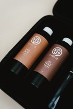 Close-up of Original N°9 olive-based and Luxe N°12 violet-based spray tan solution samples included in the Sjolie wireless kit