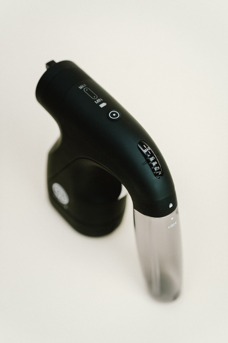 Top view of the Sjolie wireless spray tan gun showing power button and settings controls