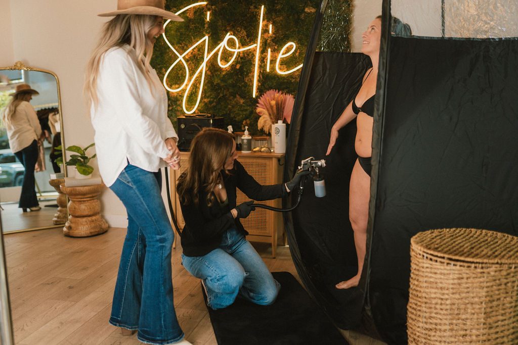 Hands-on spray tan certification training with live client practice at Sjolie sunless studio