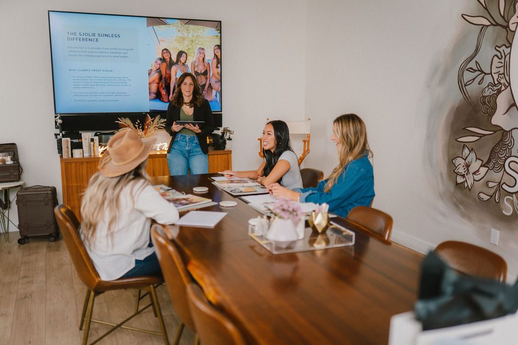 Sjolie in-person spray tan certification class with students learning sunless tanning business techniques